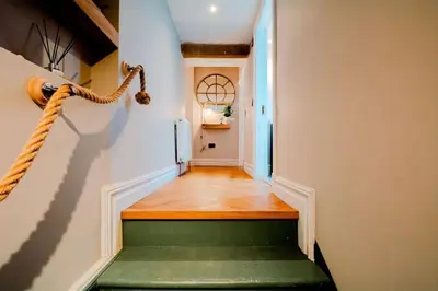 a hallway with a green stair case and a window at Number Twenty Seven luxury apartment, Aberdour, Fife in Aberdour