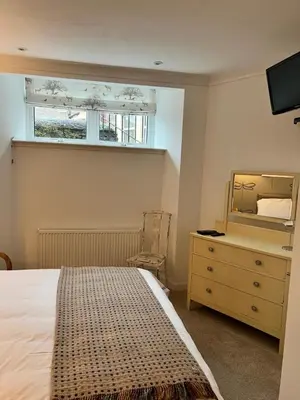 a bedroom with a bed and a dresser and a mirror at Crieff Armoury in Crieff