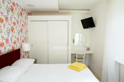a bedroom with a white bed with a yellow towel on it at Crieff Armoury in Crieff