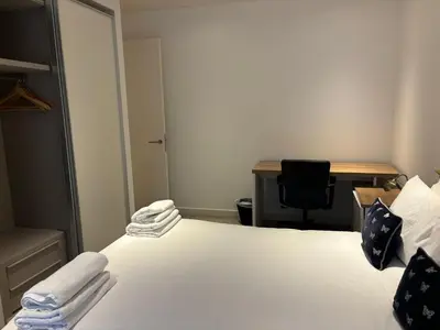 a room with a bed with a desk and a chair at Executive Quartermile apartment near to Castle University with park view in Edinburgh