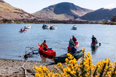 a group of people in boats on a lake at Lochranza Centre CIC in Lochranza