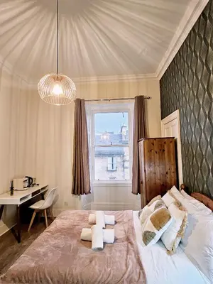 a bedroom with a bed and a desk and a window at No15 Castle View in Edinburgh