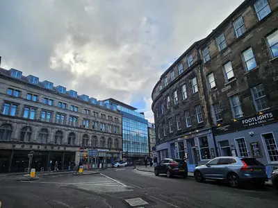 a city street with cars parked in front of buildings at No15 Castle View in Edinburgh