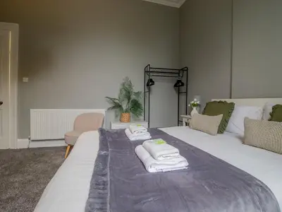 a bedroom with a large bed with towels on it at Spacious Hillhead Haven - Pass the Keys in Glasgow