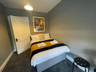 a small bedroom with a bed with two towels on it at The Blue Nile Hillhead - Pass the Keys in Glasgow