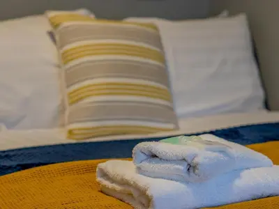 a pile of towels sitting on top of a bed at The Blue Nile Hillhead - Pass the Keys in Glasgow
