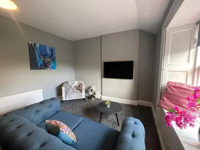 a living room with a blue couch and a tv at The Blue Nile Hillhead - Pass the Keys in Glasgow