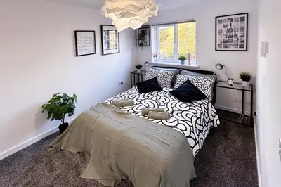 a bedroom with a bed with black and white pillows at Newbuild Riverview 3BDR House near Glasgow in Dalmuir