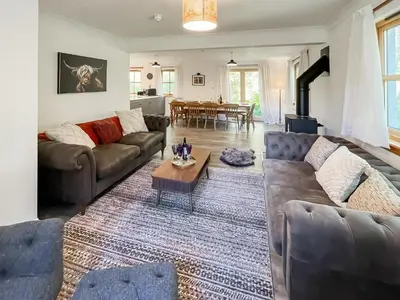 a living room with couches and a table at Fin Glen in Killin