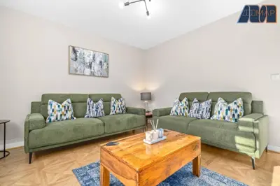 a living room with two green couches and a coffee table at Elegant 2Bed Sleeps 4 With Parking in Paisley