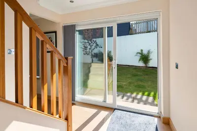 a sliding glass door in a hallway with a staircase at Stunning Sea Views - Luxury 4BR Beach House in Oban