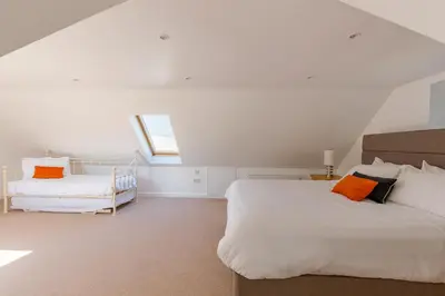 a bedroom with a bed and a window and a chair at The Stables at Brickrow Farm in Ayr