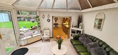 a living room with a green couch and a table at Boghead Cottage The West Wing in Bathgate