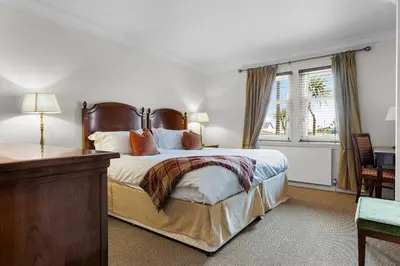 a bedroom with a large bed and a window at Ugadale Cottages in Machrihanish
