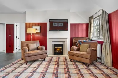a living room with two chairs and a fireplace at Ugadale Cottages in Machrihanish