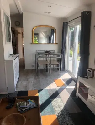 a living room with a table and a mirror at The Art Studio Arran in Isle of Arran