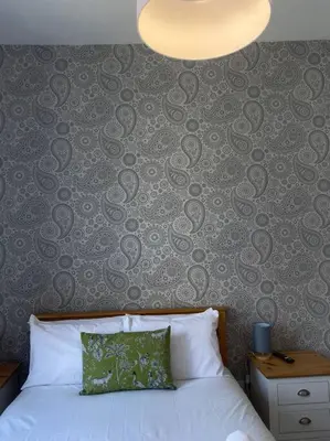 a bedroom with a bed and a wall with aoren at 3 Smithhills Paisley central spacious sleeps 4 in Paisley