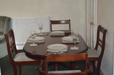 a dining room table with wine glasses on it at Carnegie Holiday Cottage in Dunfermline