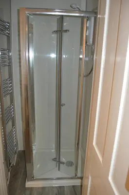 a shower with a glass door in a bathroom at Carnegie Holiday Cottage in Dunfermline