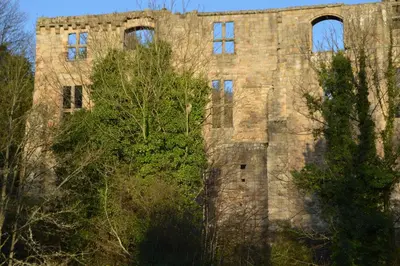 an old stone building with trees in front of it at Carnegie Holiday Cottage in Dunfermline