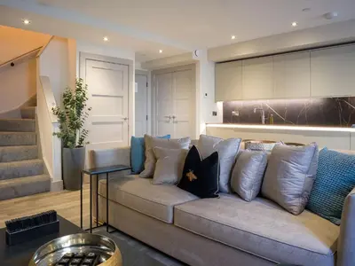a living room with a couch with pillows at Arran Shores Luxury Shorefront Apartment 3 in Lamlash