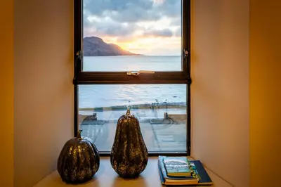 two pumpkins sitting in a window with a view of the ocean at Arran Shores Luxury Shorefront Penthouse Suite 12 in Lamlash