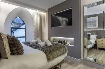 a bedroom with a bed with a large mirror at Arran Shores Luxury Shorefront Apartment 5 in Lamlash
