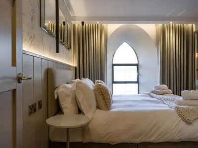 a bedroom with a large bed with a window at Arran Shores Luxury Shorefront Apartment 5 in Lamlash