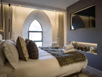 a bedroom with a large bed with an arched window at Arran Shores Luxury Shorefront Apartment 5 in Lamlash