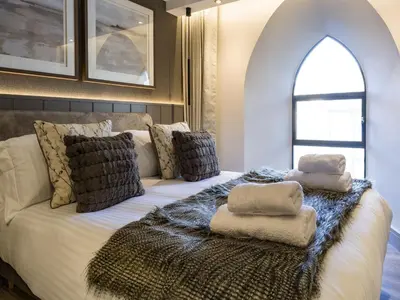 a bedroom with a bed with pillows on it at Arran Shores Luxury Shorefront Apartment 5 in Lamlash