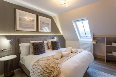 a bedroom with a large white bed with pillows at Arran Shores Luxury Shorefront Apartment 14 in Lamlash