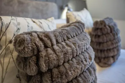 a group of pillows sitting on a bed at Arran Shores Luxury Shorefront Apartment 14 in Lamlash