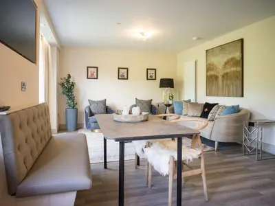 a living room with a table and a couch at Arran Shores Luxury Shorefront Garden Terrace Apartment 7 in Lamlash