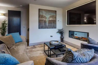 a living room with couches and a flat screen tv at Arran Shores Luxury Shorefront Suite 1 in Lamlash