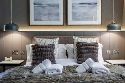 a bedroom with a bed with towels on it at Arran Shores Luxury Shorefront Apartment 8 in Lamlash
