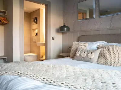 a bedroom with a large white bed and a mirror at Arran Shores Luxury Shorefront Apartment 9 in Lamlash