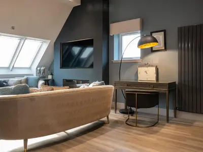 a living room with a couch and a table at Arran Shores Luxury Shorefront Penthouse Suite 10 in Lamlash