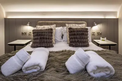 a bedroom with a large bed with towels on it at Arran Shores Luxury Shorefront Penthouse Suite 13 in Lamlash