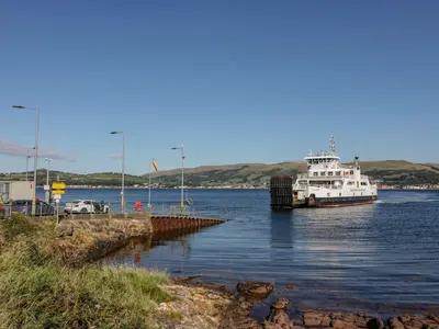 a boat is docked at a dock in the water at 8 George Street in Millport