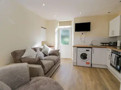a living room with a couch and a washing machine at 8 George Street in Millport