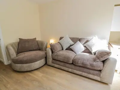 a living room with a couch and a chair at 8 George Street in Millport
