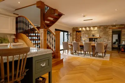a kitchen and living room with a table and chairs at Brenachoile Cottage in Callander