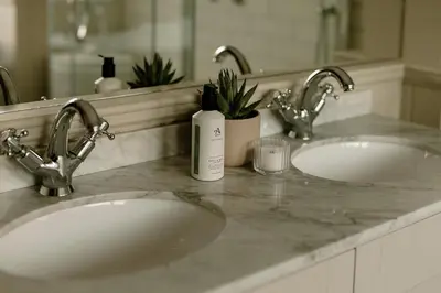 a bathroom counter with two sinks and a bottle of soap at Brenachoile Cottage in Callander
