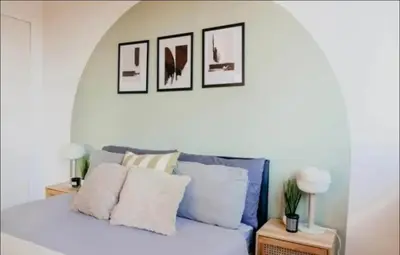 a bedroom with a bed with four pictures on the wall at Glasgow City Centre Apartment in Glasgow