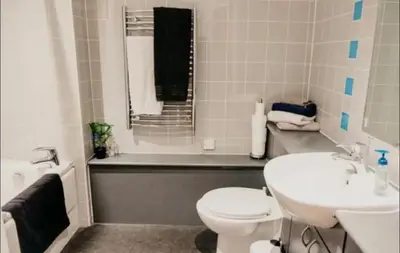 a bathroom with a toilet and a sink and a tub at Glasgow City Centre Apartment in Glasgow