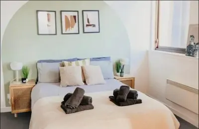 a bedroom with a bed with two brown towels on it at Glasgow City Centre Apartment in Glasgow