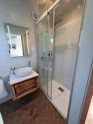 a bathroom with a glass shower and a sink at East Rigg Lodges in Balerno