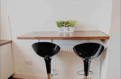 two black chairs under a wooden table in a room at Glasgow City 1 Bedroom Apartment in Glasgow