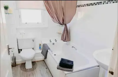a bathroom with a toilet and a tub and a sink at Glasgow City 1 Bedroom Apartment in Glasgow