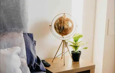 a globe on a stand next to a table with a plant at Glasgow City 1 Bedroom Apartment in Glasgow